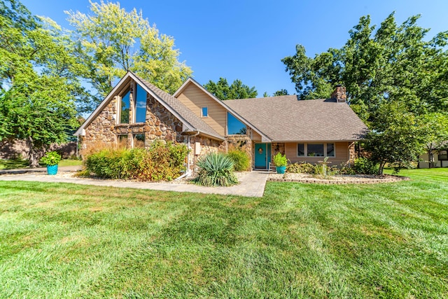 view of front of property with stone siding, a shingled roof, a chimney, and a front yard