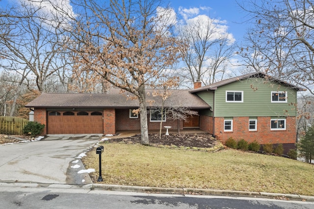 tri-level home with a garage, a front lawn, a chimney, and brick siding