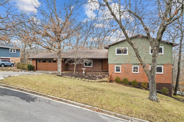 tri-level home featuring driveway, brick siding, a front lawn, and an attached garage