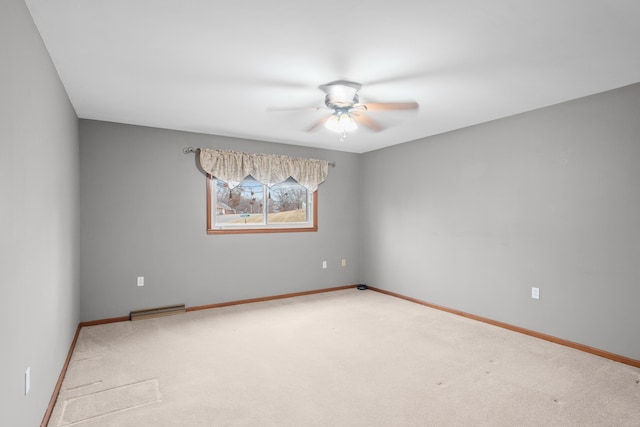 unfurnished room featuring carpet floors, visible vents, baseboards, and a ceiling fan