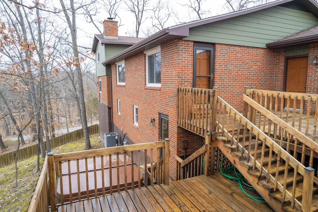 wooden terrace featuring central air condition unit, fence, and stairway