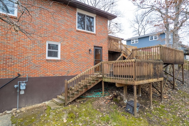 back of property featuring stairs, brick siding, and a wooden deck