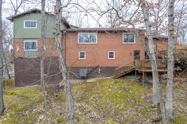 back of property featuring brick siding, stairway, and a wooden deck