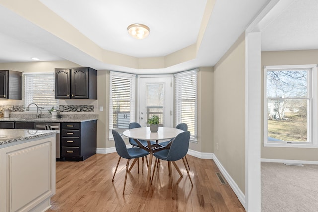 dining space with visible vents, light wood-style flooring, and baseboards