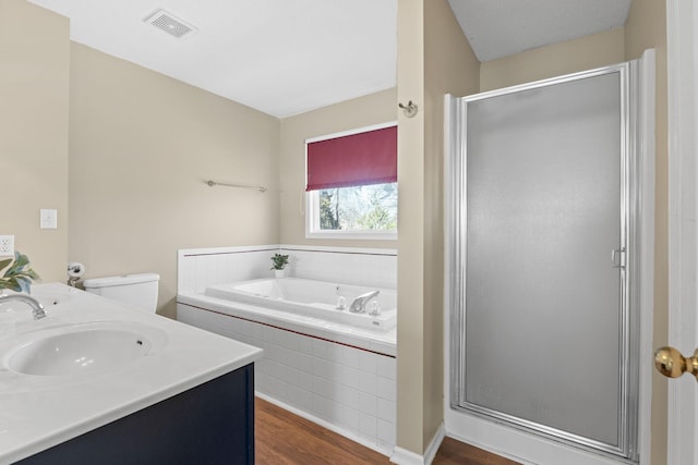 full bathroom featuring a stall shower, visible vents, wood finished floors, a sink, and a bath