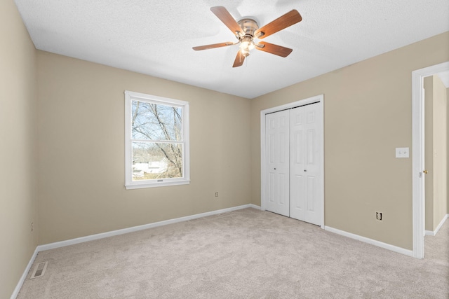 unfurnished bedroom with a closet, carpet flooring, and visible vents