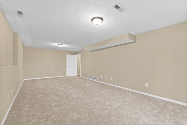 carpeted empty room with visible vents and a textured ceiling