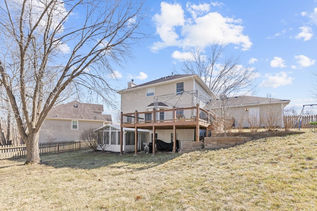 back of house with a chimney, a wooden deck, a lawn, and fence