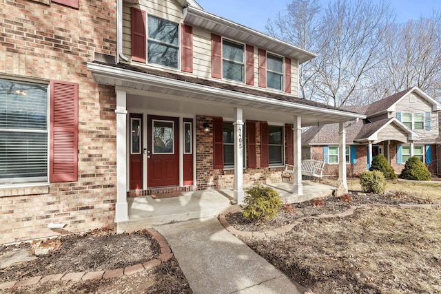 view of front facade with covered porch and brick siding