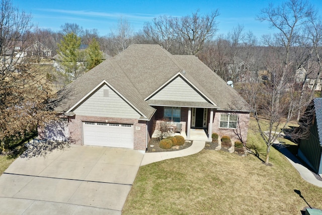 view of front of property with covered porch, a shingled roof, brick siding, driveway, and a front lawn