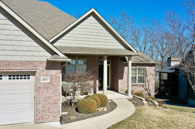 view of front of home featuring a garage, brick siding, and roof with shingles