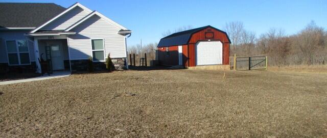 view of yard with a shed, a detached garage, and an outdoor structure