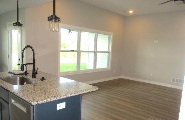 305 E Francis St, Sturgeon, MO 65284 - kitchen featuring a sink, a ceiling fan, baseboards, light stone counters, and wood finished floors