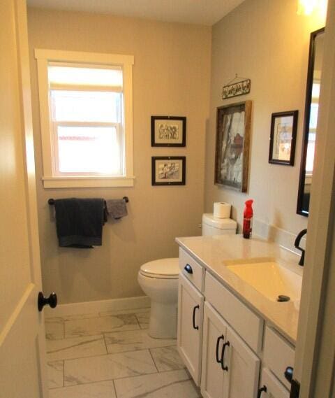 305 E Francis St, Sturgeon, MO 65284 - bathroom featuring marble look tiles, toilet, vanity, and baseboards
