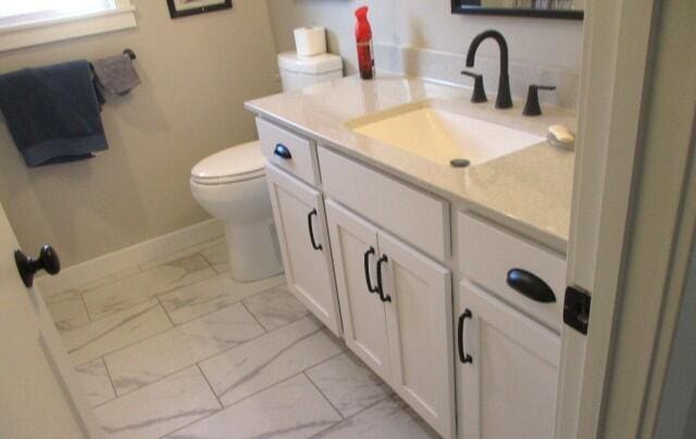 305 E Francis St, Sturgeon, MO 65284 - bathroom with marble finish floors, toilet, vanity, and baseboards