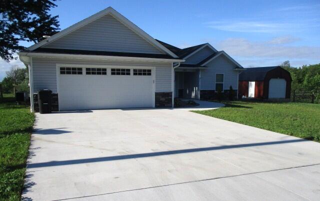 305 E Francis St, Sturgeon, MO 65284 - view of front of house featuring an attached garage, driveway, and a front yard