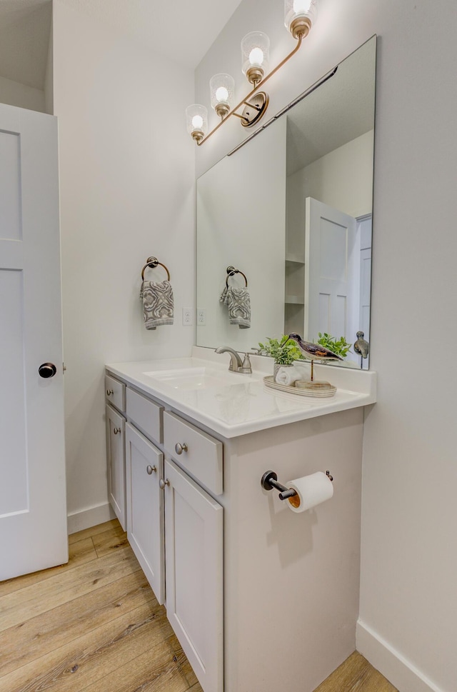 bathroom featuring wood finished floors, vanity, and baseboards