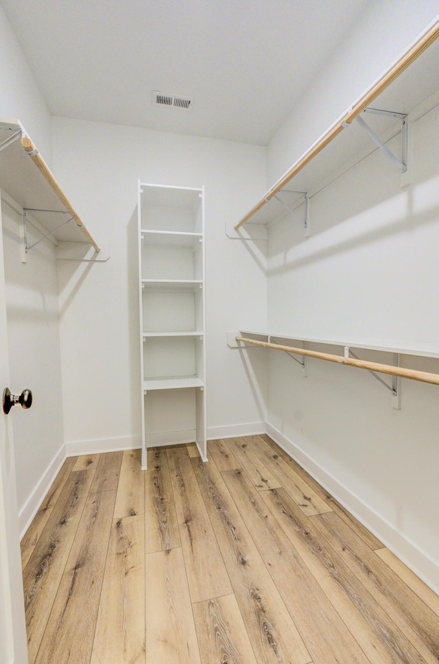 walk in closet with visible vents and hardwood / wood-style flooring