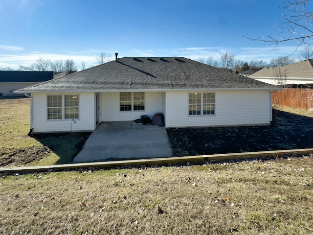 rear view of property with a yard, a shingled roof, a patio area, and fence