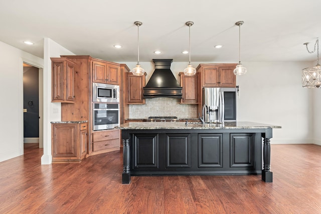 kitchen with dark wood-style floors, brown cabinets, stainless steel appliances, custom range hood, and backsplash