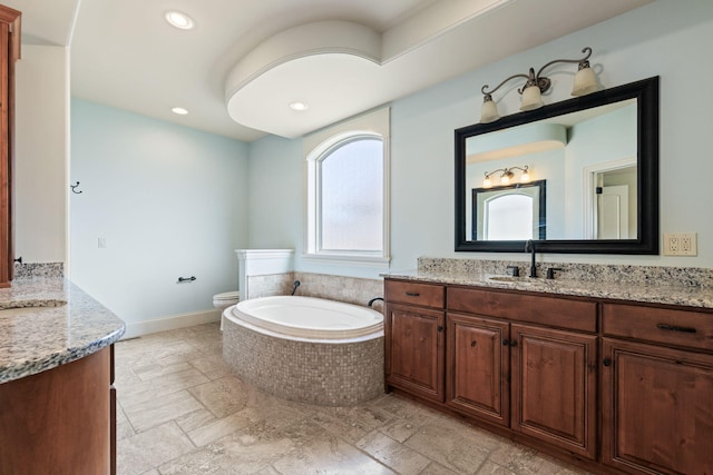 bathroom featuring a garden tub, stone tile floors, vanity, and toilet