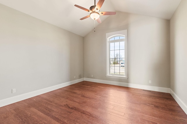 empty room featuring lofted ceiling, visible vents, ceiling fan, wood finished floors, and baseboards