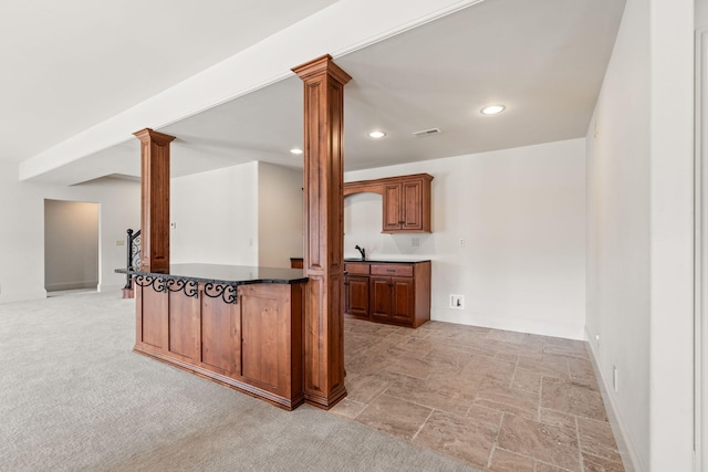 kitchen with dark countertops, baseboards, ornate columns, and recessed lighting