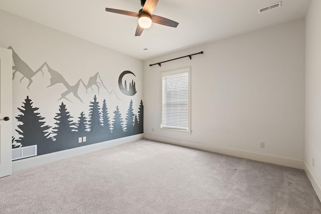 carpeted empty room featuring baseboards, visible vents, and a ceiling fan