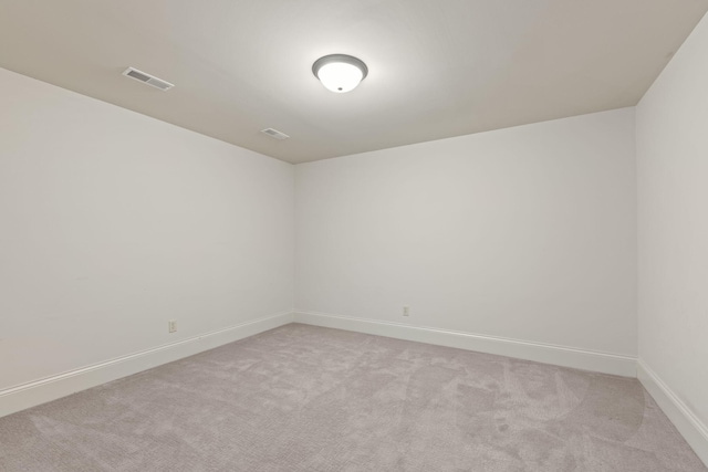 unfurnished room featuring light colored carpet, visible vents, and baseboards