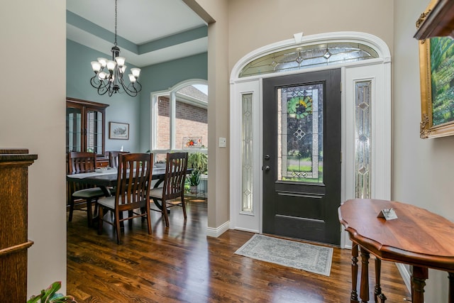 foyer featuring dark wood-style floors, baseboards, and a notable chandelier