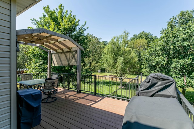 wooden deck featuring a grill and a pergola