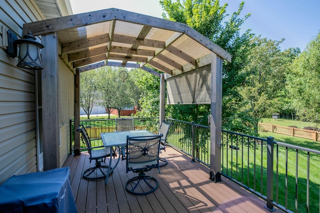 wooden deck featuring outdoor dining space and a lawn