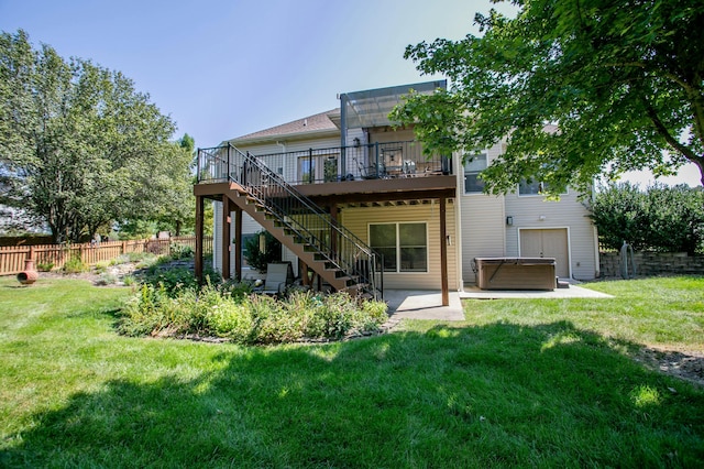 back of house featuring a hot tub, a yard, stairs, fence, and a wooden deck