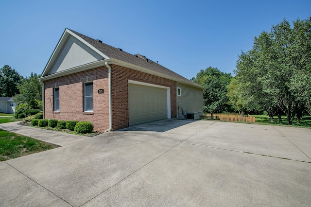 view of property exterior featuring a garage, concrete driveway, and brick siding