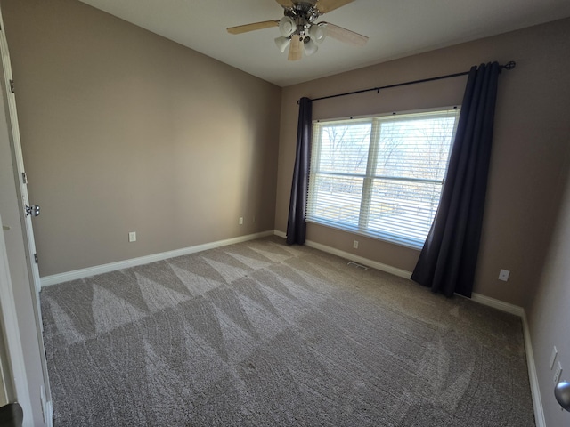 unfurnished room with baseboards, visible vents, ceiling fan, and light colored carpet