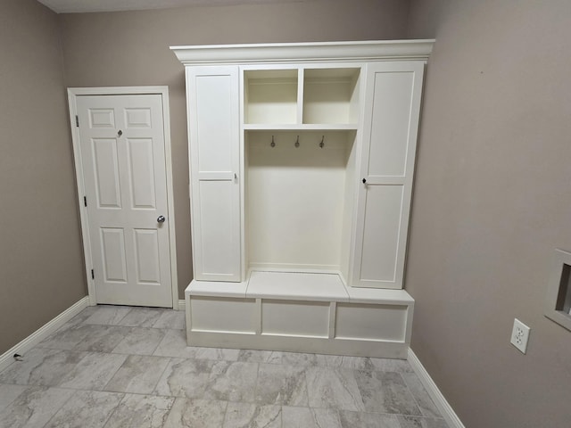 mudroom with marble finish floor and baseboards