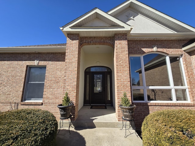 doorway to property featuring brick siding