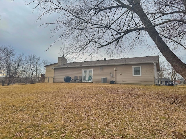 back of house featuring a yard, french doors, central AC unit, and a chimney