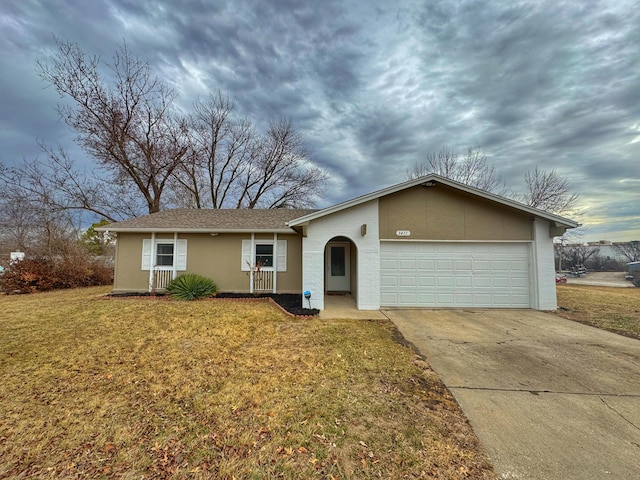 ranch-style home featuring an attached garage, a front lawn, concrete driveway, and stucco siding