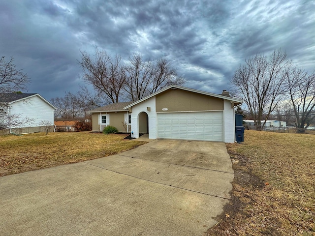 ranch-style house featuring driveway, an attached garage, a chimney, and a front yard