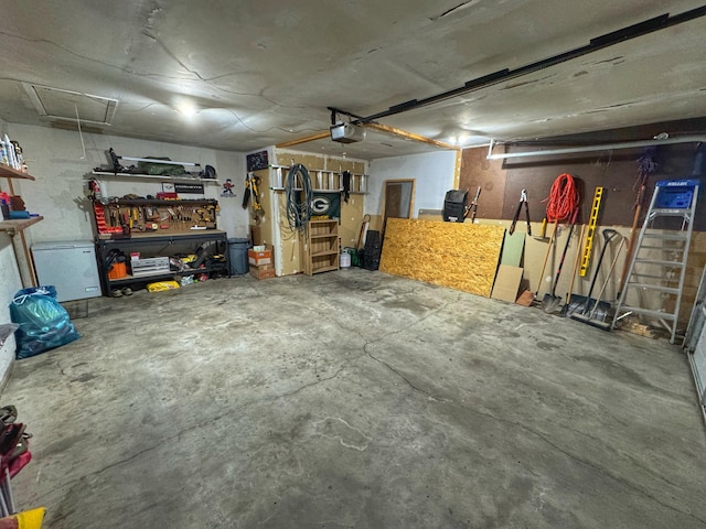 garage with a garage door opener and a workshop area