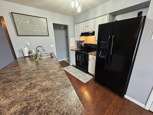 kitchen with dark wood-style flooring, under cabinet range hood, a textured ceiling, black appliances, and a sink