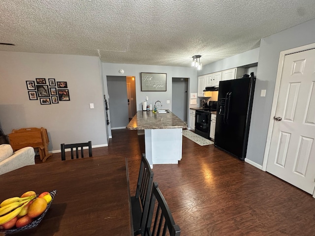 kitchen featuring extractor fan, a sink, white cabinets, dark wood-style floors, and black appliances