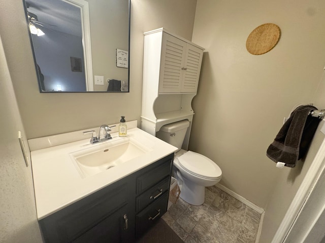 bathroom with baseboards, vanity, and toilet