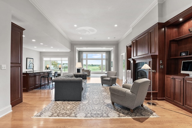 living room with crown molding, baseboards, light wood-style flooring, and recessed lighting