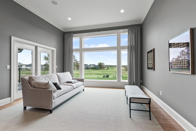 living room featuring baseboards, light wood finished floors, and crown molding