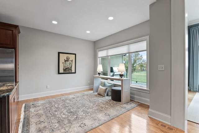 office area with light wood-style flooring, visible vents, baseboards, and recessed lighting