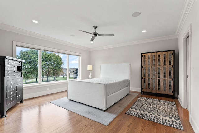 bedroom with ornamental molding, recessed lighting, baseboards, and wood finished floors