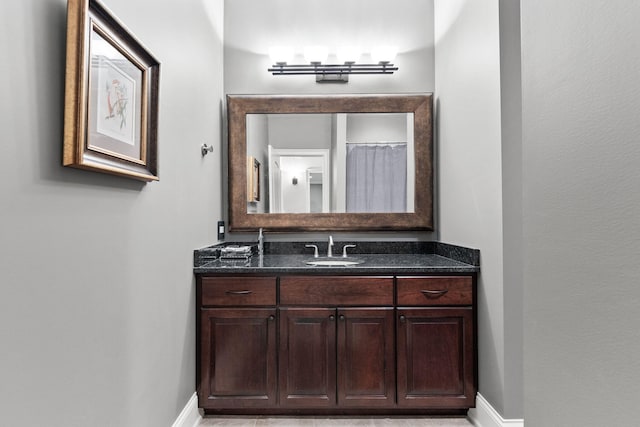 full bath featuring a shower with curtain, vanity, and baseboards