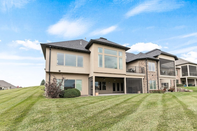 back of house featuring a patio, a lawn, a balcony, and stucco siding